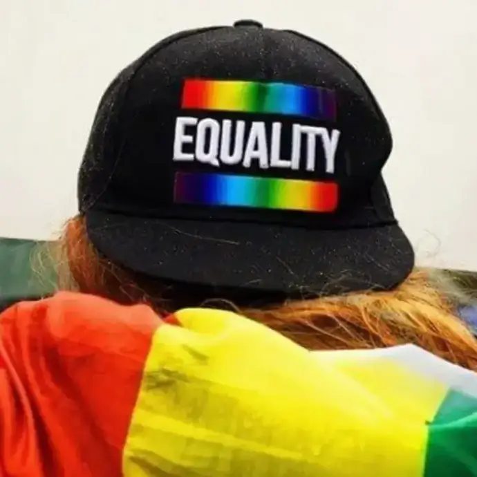 Equality and diversity: person wearing hat with rainbow colours and equality text.